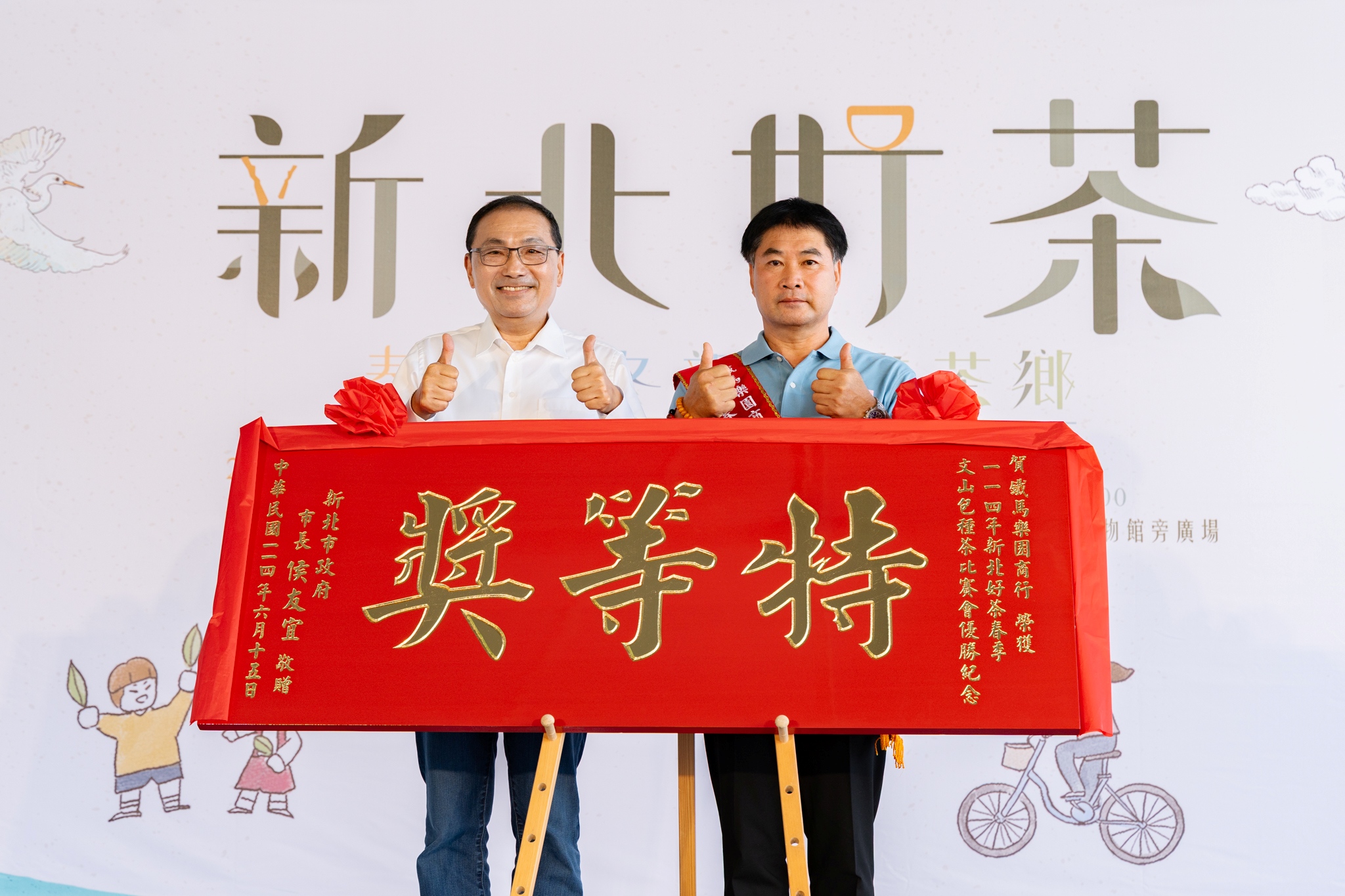 新北市長侯友宜(左)今(15)日頒發賀匾予春茶評鑑特等獎得主方均銓(右)。