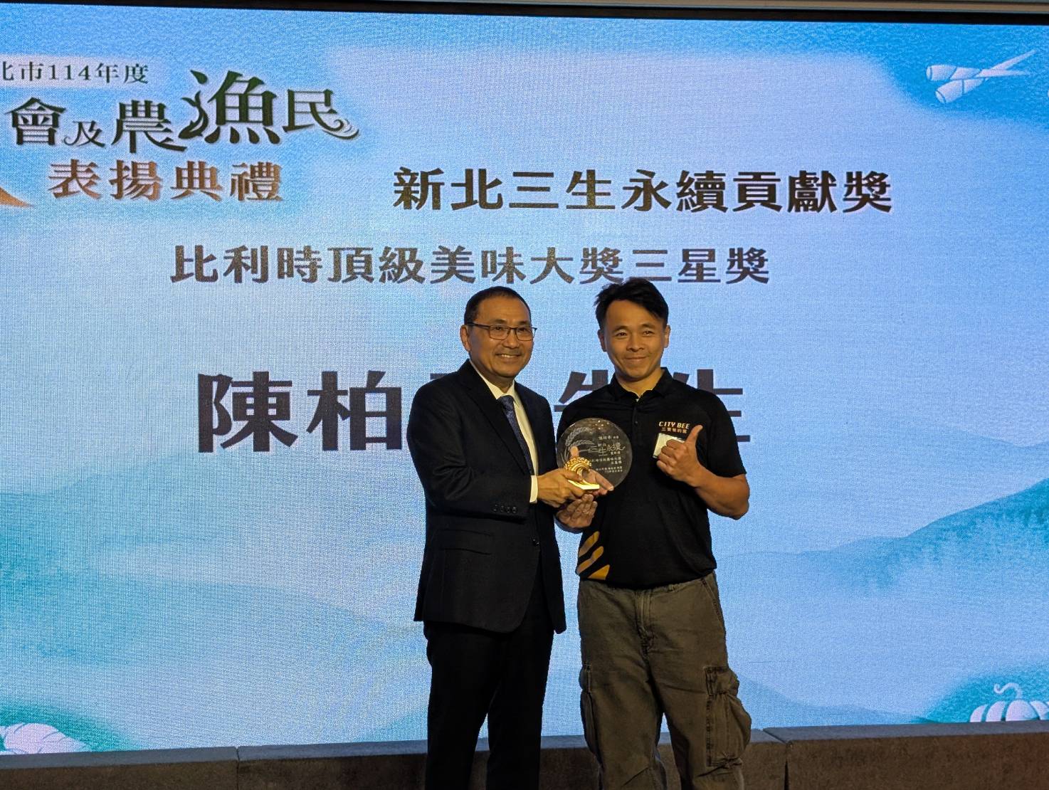 青農陳柏承(右)生產蜂蜜並轉化為具附加價值產品,榮獲「比利時頂級美味大獎三星獎」榮耀,市長侯友宜頒發「新北三生永續貢獻獎」表揚青農陳柏承的創新實力